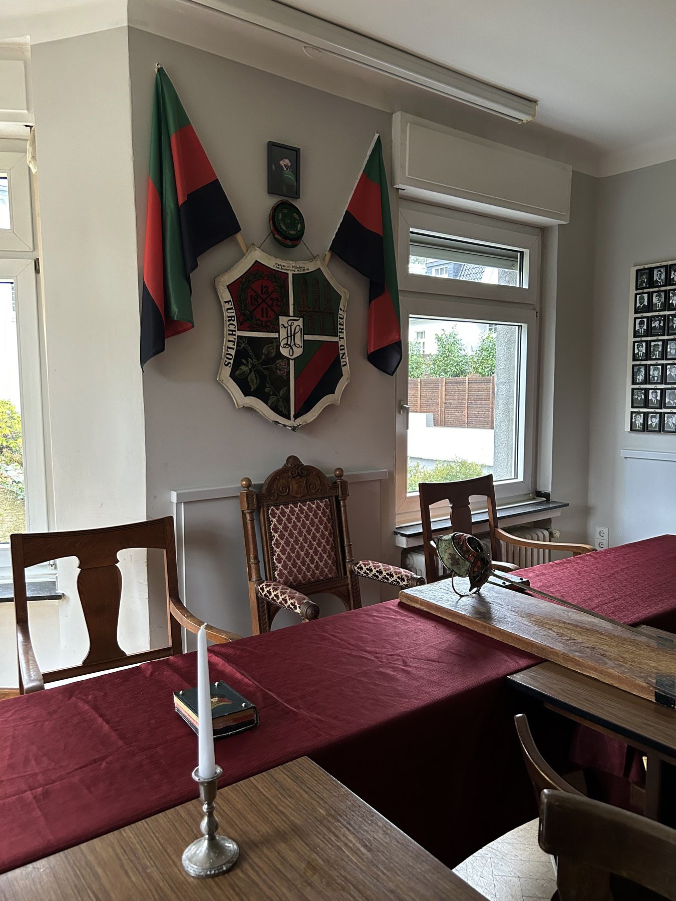 Kneipsaal mit Wappen, Fahnen und langem Tisch